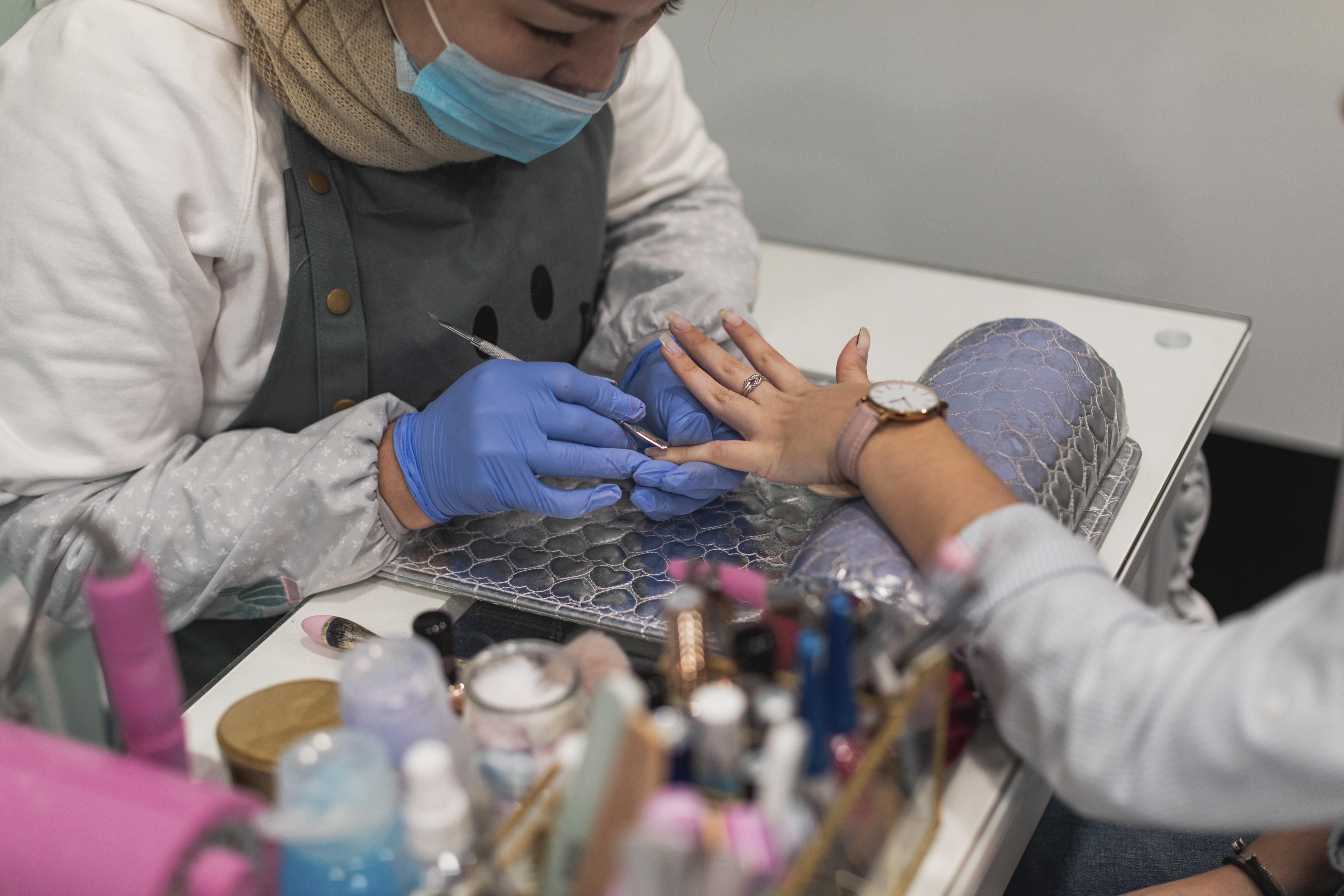 Nail artist applying nail polish for a client at Angel Nail & Beauty Lab.